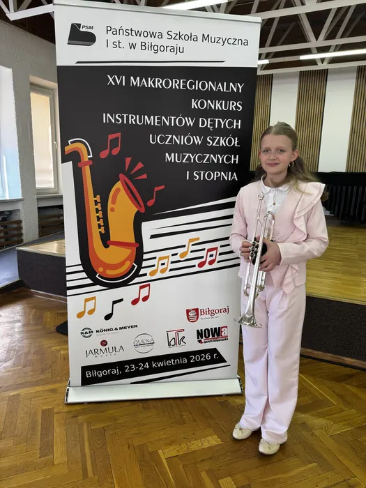 Hania z trąbką przy plakacie konkursu w Biłgoraju